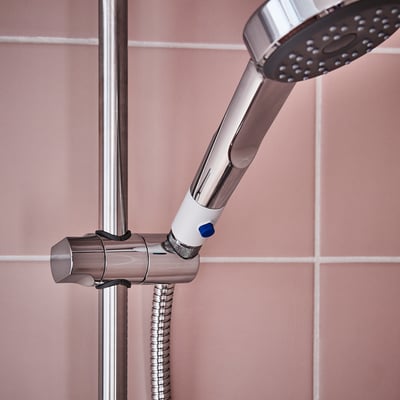 Silver BERGVATTNET duschbooster monterad på rosa plattor, liten, kromad, akrylkropp.