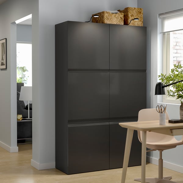 Modernt vardagsrum med svart BESTÅ-förvaring, med flera hyllor och minimalistisk design.