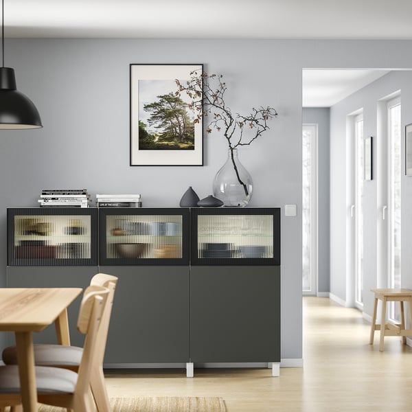Modernt vardagsrum med IKEA BESTÅ-enhet, dekorativa föremål och snygg belysning.