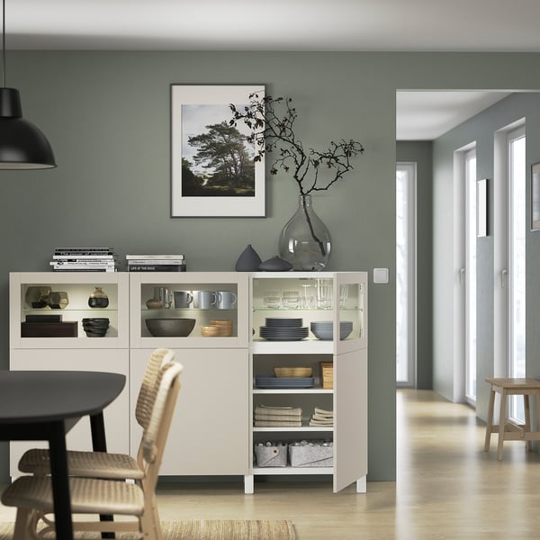 Modern matsal med skänken BESTÅ, glasdörrar, organiserade hyllor och naturfoto.