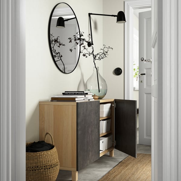 Sideboard-kombination med justerbara hyllor, mjukstängande dörrar och förvaringslådor. En stor spegel och vägglampa ovanför.
