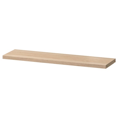 En ikea BESTÅ justerbar trähylla. Den är rektangulär, ljusbrun och gjord av spånskiva med plastkant.