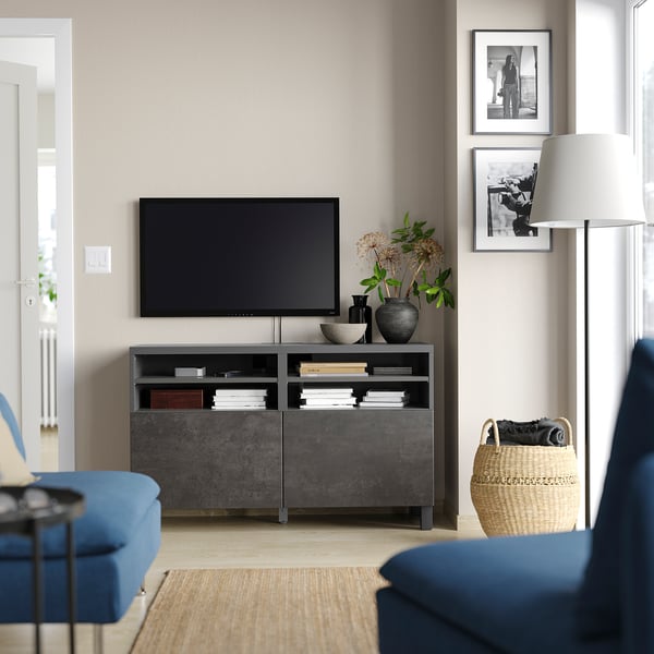 Vardagsrum med modern decentraliserad underhållning, med svart BESTÅ-tv-bänk, plattskärm, blå soffa och inredning.