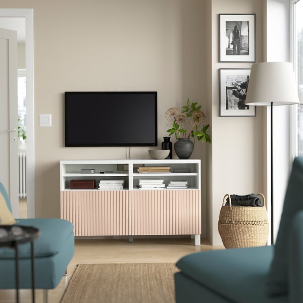 Modernt vardagsrum med tv-bänken BESTÅ, blågröna fåtöljer, plattskärms-tv, böcker, förvaring, korg, lampa, vaser, bilder.