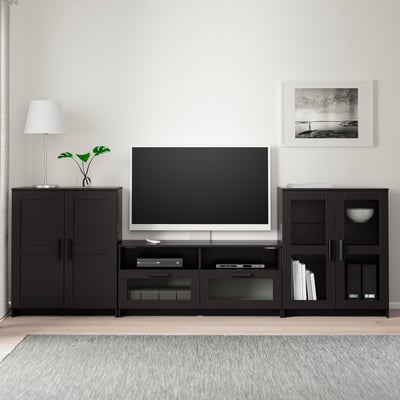 Modern svart tv-installation: brett stativ, plattskärm, vit lampa, konst.