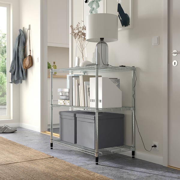 Modern entré med grå DRÖNA förvaringslådor på metallhylla under skåp. Grått lock på den mittersta lådan. Utrymmesbesparande design.