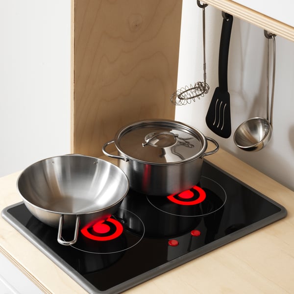 Köksredskap i rostfritt stål för barn på leksaksspis med handtag.