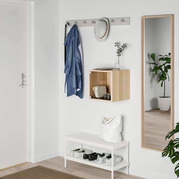 Organiserad entré med vitt EKET-skåp, trähylla, hängskena, spegel och växter.