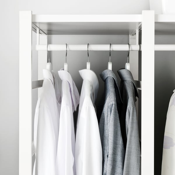 Garderob med vit ELVARLI-skena, hängande skjortor och tröja; snygg organisation.