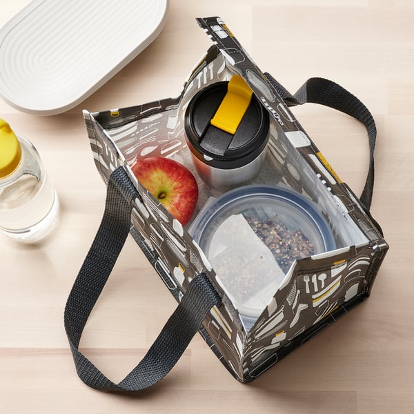 Isolerad resemugg i påse med äpple och snacks, perfekt för när du är på språng.