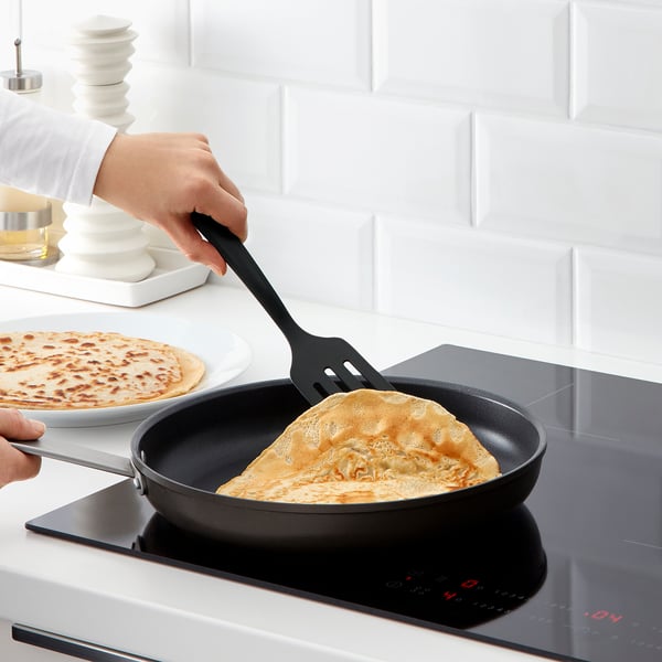 Person som lagar pannkakor med GNARP-redskap och spatel på en non-stick stekpanna.