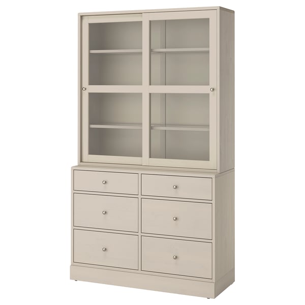 En beige möbelmöbel HAVSTA med sex lådor och glasdörrar som kombinerar rustik furu och modern design.