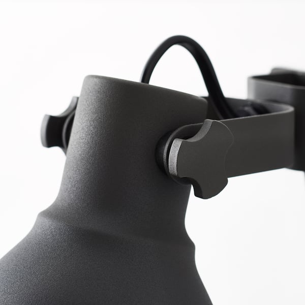 Svart justerbar metalllampa i närbild, som visar robust design och handtag i rostfritt stål.