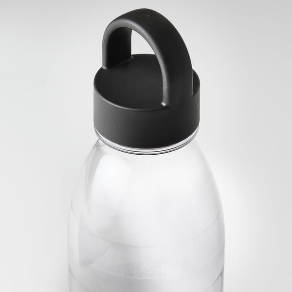 Vattenflaska i genomskinlig plast med svart lock, med ett robust öglehandtag och robust design. Idealisk för hållbar, daglig användning.