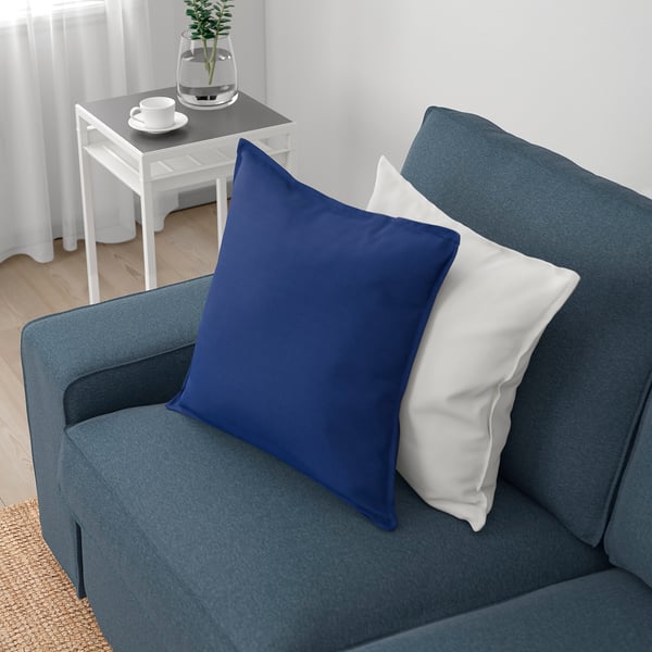 En mysig blå soffa med avtagbara armstöd och en djup sits, perfekt för avkoppling och för att ta emot gäster.