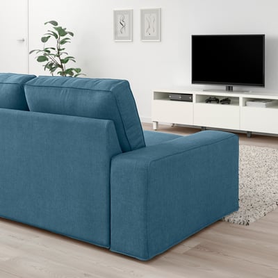 Modern blå KIVIK soffa i vardagsrum med tv, växt och modern inredning.