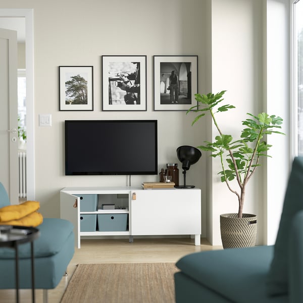 Modernt vardagsrum med tv på vit LAPPVIKEN förvaring, växter och inramade bilder.