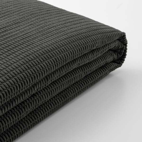 Närbild av en mjuk, texturerad svart filt, snyggt vikt.