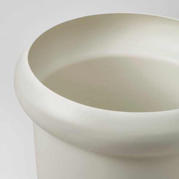 Närbild på en matt vit kruka med släta, böjda kanter. Ytan verkar hållbar och lätt, designad för utomhusanvändning.