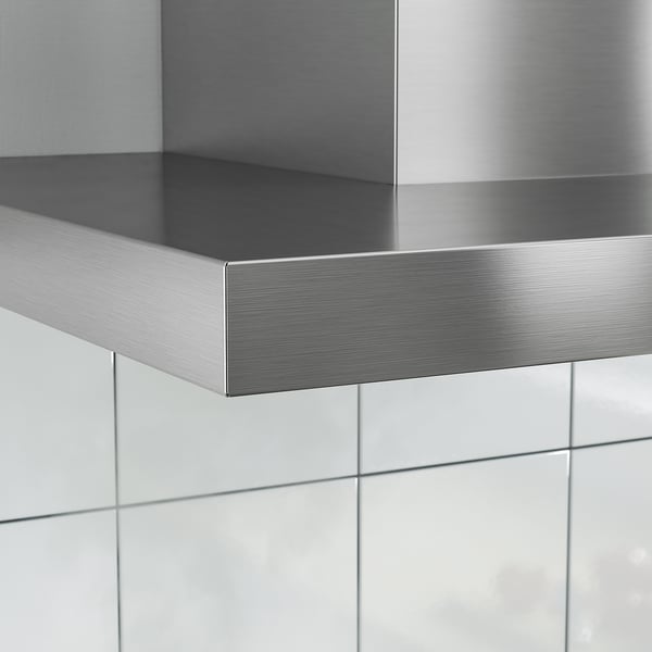 Modern köksfläkt i silver i rostfritt stål monterad på väggen, reflekterande ljus och elegant design.