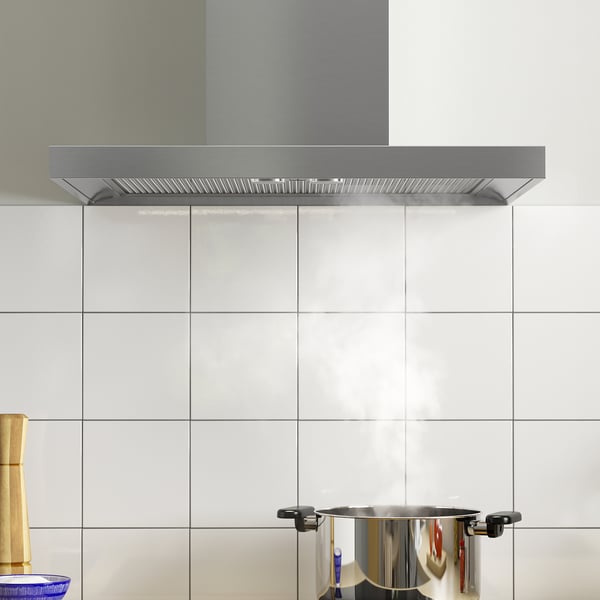 Köksfläkt med led-ljus över spishällen, vitt kakel.