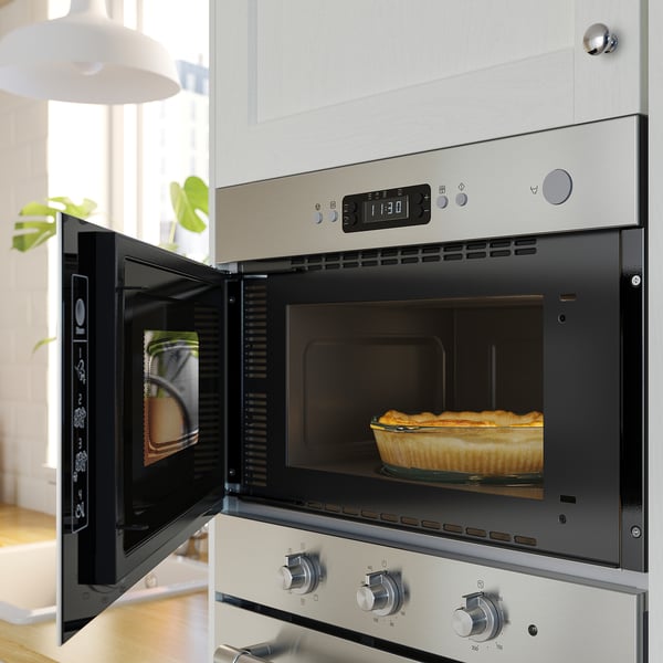 Öppen ugn i rostfritt stål med ugnsbakad form inuti, digital display på toppen, modern köksinställning.