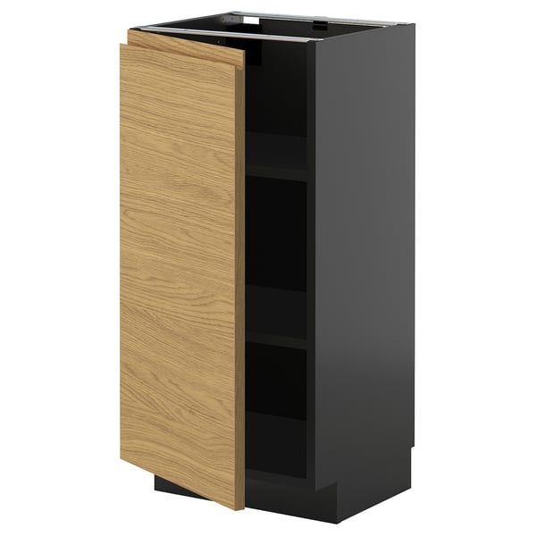 Ett modernt köksskåp med namnet METOD med en ljusbrun trädörr och en mörkgrå sockel. Den har en minimalistisk design med integrerade handtag.