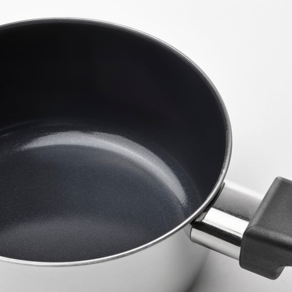 Kastrull med blank, non-stick yta och silverhandtag. Keramisk beläggning av hög kvalitet är synlig.