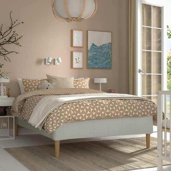 Modern sovrum med RÅHOLMAR-säng, grå tuftdesign, beige sängkläder, varm lampa, minimalistisk inredning.
