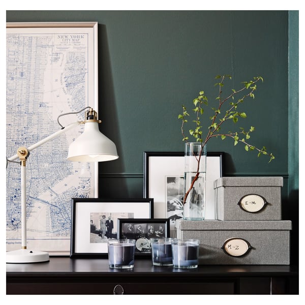 Svart skrivbord med vintagelampa, NYC-karta, foton, vaser och förvaringslådor.