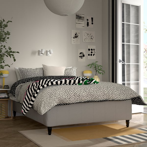 Modernt sovrum med sängen RISHÖJDEN , konst, lampa, växt och stort fönster.