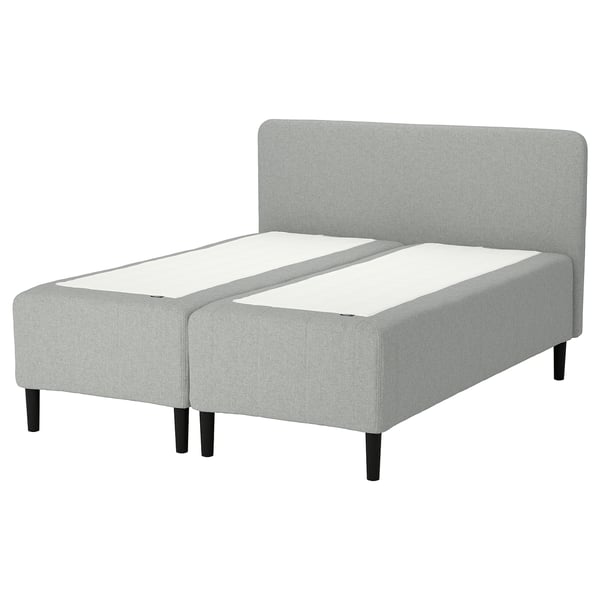 Rishojden-sängen är en modern, ljusgrå tygdesign med hög sänggavel och mörka träben, med justerbara komfortzoner.
