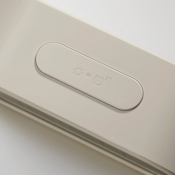 Modern klocka med upplyst oval panel som visar tids- och väderikoner, slank metallisk finish.