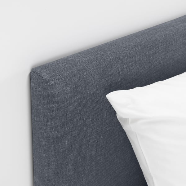 Sänggavel i grått tyg i en modern, bekväm säng med rena linjer och stödjande design.
