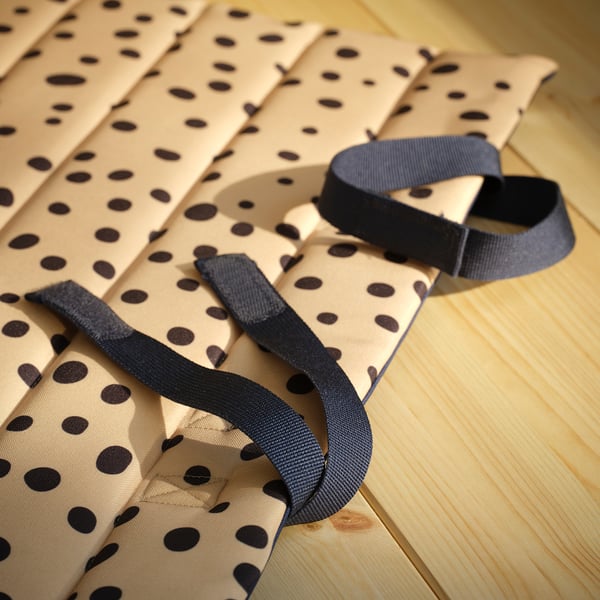 Vikt prickig tygmatta med slitstarka remmar på trägolv.