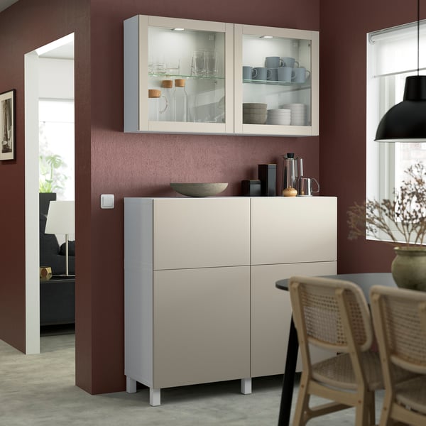 SINDVIK sideboard i ljust gråbeige, med glasdörrar, passar under hängande skåp. Displayer paraboler och elektronik, med modern design.