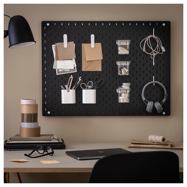 SKÅDIS svart pärlplatta organiserar kontorsmaterial med tillbehör: klämmor, koppar och krokar på beige vägg.