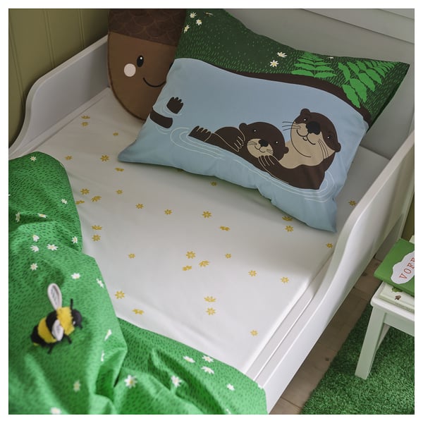 Blå björnsäng med grön filt och pall, plyschleksak, trädtryck.