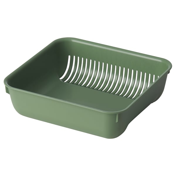 En grön SKOLÄST-sil. Den är fyrkantig med ett dräneringsgaller inuti. Tillverkad av robust plast med halkfria fötter, perfekt för diskbänkar.