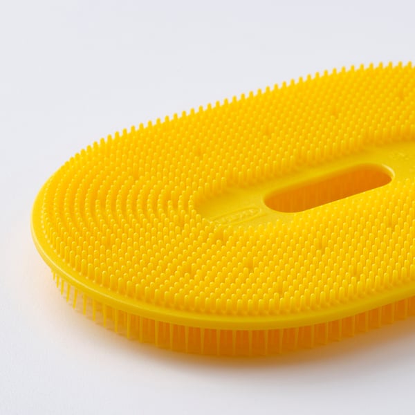 Ljusgul grönsaksborste med texturerad yta, designad för att skrubba rötter. Mjuka, flexibla borst för skonsam rengöring.