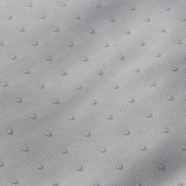 Närbild av slitstarkt, strukturerat tyg, troligen en husdjurssäng, som visar vattenavvisande egenskaper med droppar på ytan.