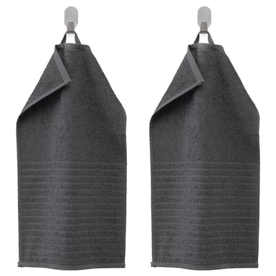 Två mörkgrå handdukar VÅGSJÖN hänger sida vid sida på krokar, med randig struktur och vikta toppar.