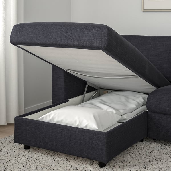 Modern grå soffa med utdragbar sovdel, förvaringsfack öppet.