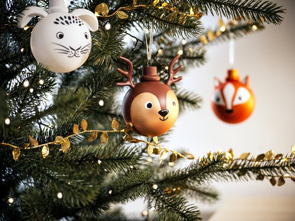 Julgran dekorerad med VINTERFINT-prydnader : brunt hjorthuvud, orange räv, vit katt, guldblad, gröna ljus.