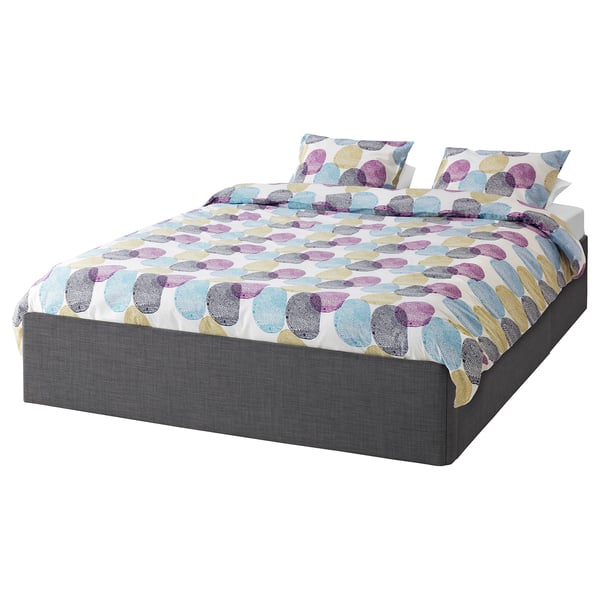 A BALESTRAND bed with multicoloured polka dot bedding and dark grey base.
