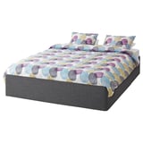 A BALESTRAND bed with multicoloured polka dot bedding and dark grey base.