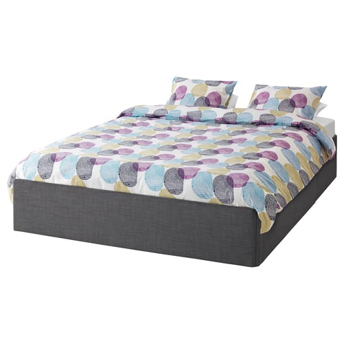 A BALESTRAND bed with multicoloured polka dot bedding and dark grey base.