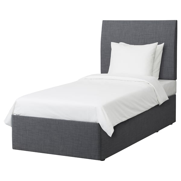 A grey BALESTRAND bed with white linens and a grey upholstered headboard and frame.