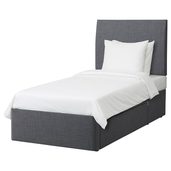 Modern grey fabric bed with upholstered headboard and white linens.