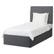 Modern grey fabric bed with upholstered headboard and white linens.